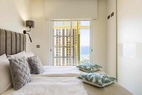 a bedroom with a bed with a large window at Intempo Residential Sky Resort & Spa - Benidorm, España in Benidorm