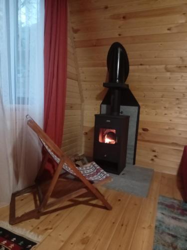 a wood stove in a room with a chair at Cottage Mida in Mestia