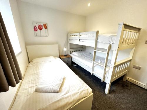 1 Schlafzimmer mit 2 Etagenbetten und einem Fenster in der Unterkunft Maisy Lodge - Two Bed Lux Flat - Parking, Netflix, WIFI - Close to Blenheim Palace & Oxford - F2 in Kidlington