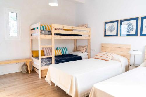 una camera con 2 letti e un letto a castello di VILLA BINISABEL NOU, CONFORT Y EXCLUSIVIDAD a Sant Lluís