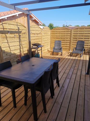 un patio avec une table et des chaises sur une terrasse dans l'établissement La Caza Cozy, à La Teste-de-Buch