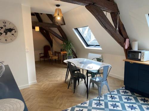 une cuisine et une salle à manger avec une table et des chaises dans l'établissement Le KT-Dral - Appartement hypercentre, à Bourges
