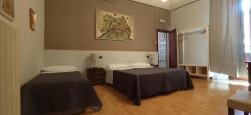 Habitación con 2 camas y una foto en la pared. en B&B Antica Piazza dei Miracoli, en Pisa