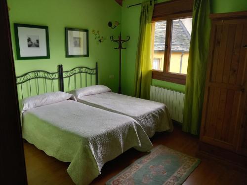um quarto verde com 2 camas e uma janela em Casa Rural La Fuente em Tejedo del Sil