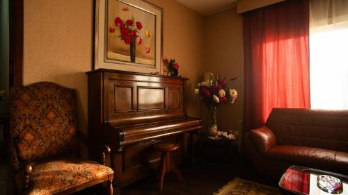 a living room with a piano and a chair at The Villa 604 Powered by look in Cairo