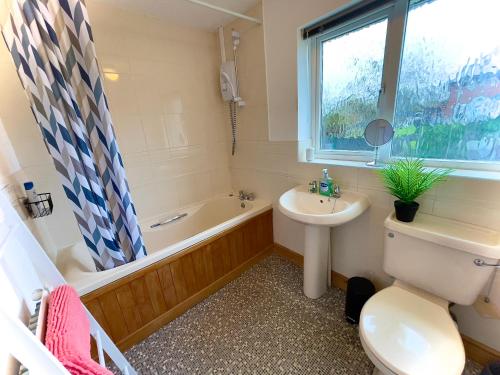 a bathroom with a sink and a toilet and a bath tub at Charming Home in Wellingborough in Wellingborough