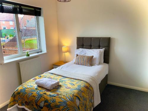 a bedroom with a bed with a pillow and a window at Charming Home in Wellingborough in Wellingborough