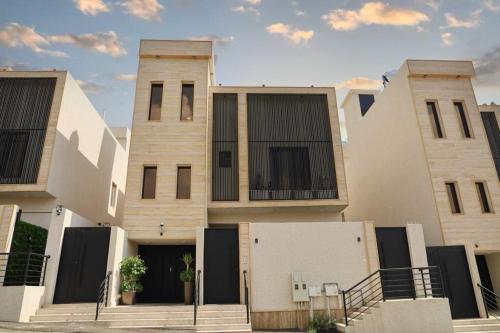grupa trzech budynków z otwartymi drzwiami w obiekcie نزل ليلى الفندقية الفاخرة luxury w mieście Abha
