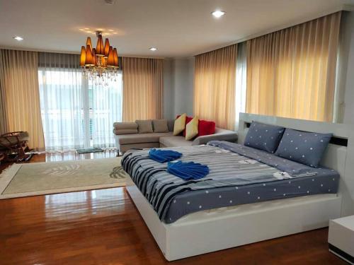 a bedroom with a large bed and a couch at Beach Palace Condomenium (Chaam-Huanhin) in Ban Bo Khaem