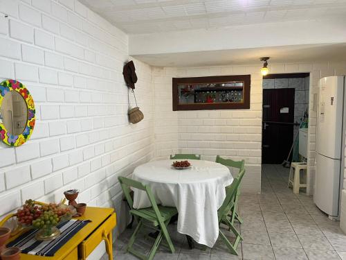 a kitchen with a table and green chairs in a room at Hostel Porto Vip in Porto De Galinhas