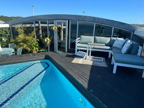 a deck with a couch and a swimming pool at DNA Dream Home in Durban