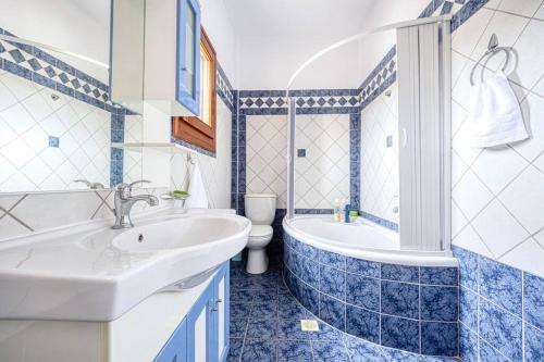 uma casa de banho com um lavatório, uma banheira e um WC. em Villa Vasiliki em Vasilikí
