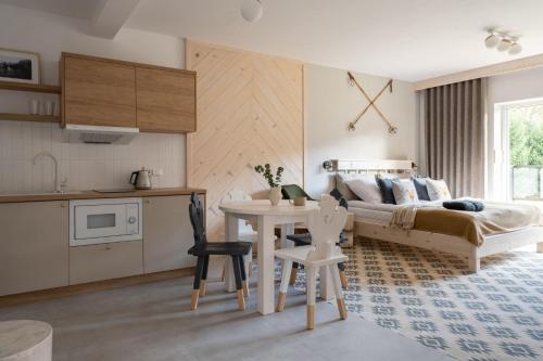 a bedroom with a bed and a table and a kitchen at Kominkowy Chill in Biały Dunajec