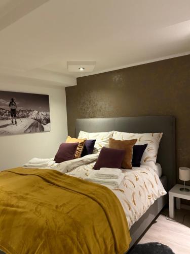 una camera da letto con un grande letto con una coperta gialla di Wohnung mit Stil im Herzen Tirols a Thaur