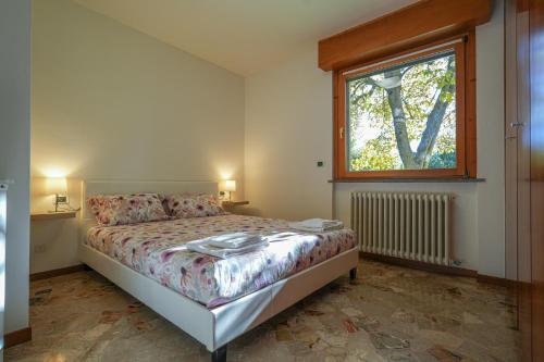 um pequeno quarto com uma cama e uma janela em La Magnolia em Calolziocorte