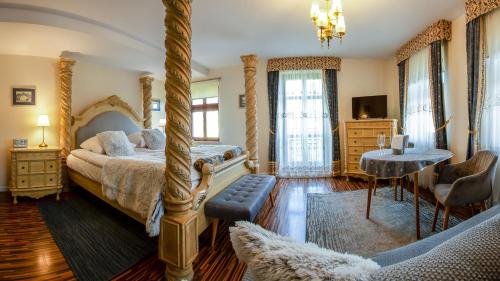 sypialnia z łóżkiem z baldachimem i stołem w obiekcie Hotel Maria Helena w Szczawnie Zdroju