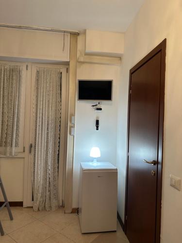 a room with a door and a table with a lamp at Gigli, rooms con cucina in comune e terrazza in Milan