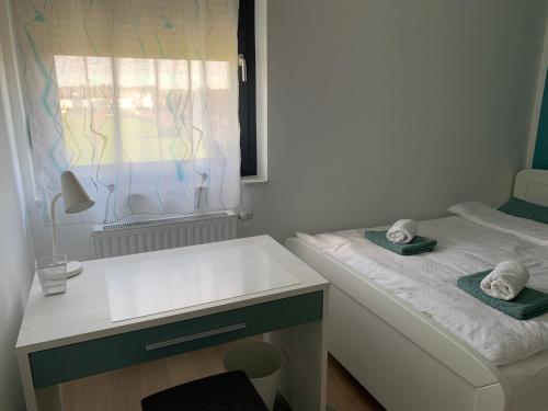 a small room with a bed and a sink at Apartman Santosha in Čakovec