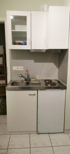 a kitchen with white cabinets and a sink at Ruhige Wohnung, citynah und kinderfreundlich in Rostock