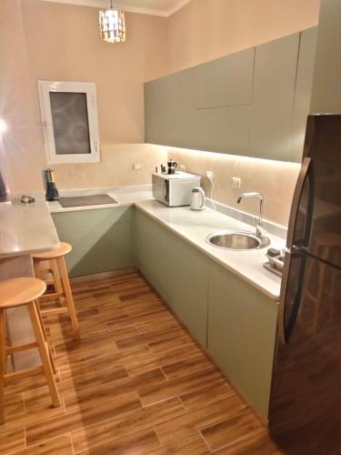 a small kitchen with a sink and a refrigerator at LuxuryGetaway2 / Brand New 2BR / Fully Furnished / Wi-Fi / Full Kitchen in Sharm El Sheikh