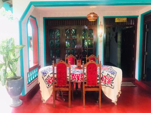 a dining room table with chairs at Unakuruwa silent beach villa in Tangalle