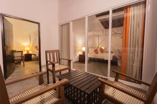 a room with two wooden benches and a bedroom at Hotel Zeilan Sunset Point in Unawatuna