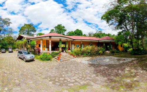 una casa con un coche aparcado delante de ella en Finca Alcalá, un paraíso cerca a Bogotá! en Ubaque