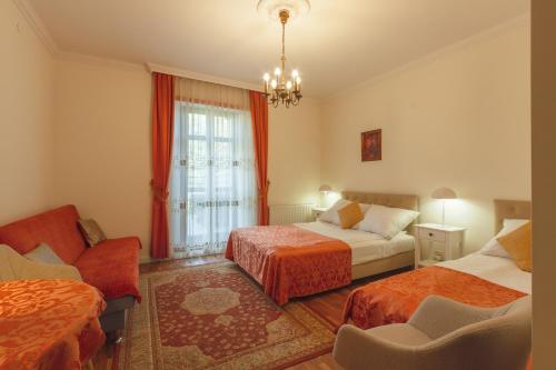 a hotel room with two beds and a couch at Hotel Maria Helena in Szczawno-Zdrój