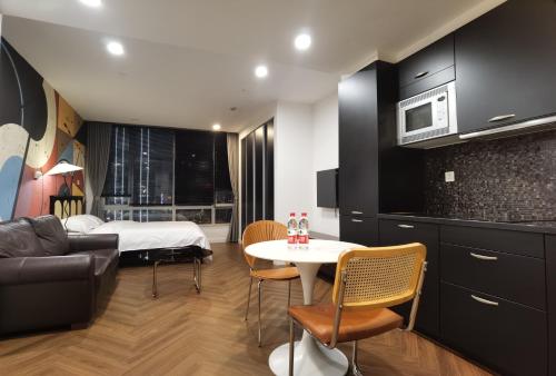 a kitchen and living room with a bed and a table at River House Near The Peoples Square And The Bund in Shanghai