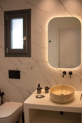 a bathroom with a sink and a toilet and a mirror at Juliano luxury apartments, port of Naxos in Naxos Chora