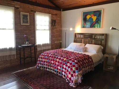 a bedroom with a bed with a quilt on it at Quinta da Prata in Bocaina de Minas