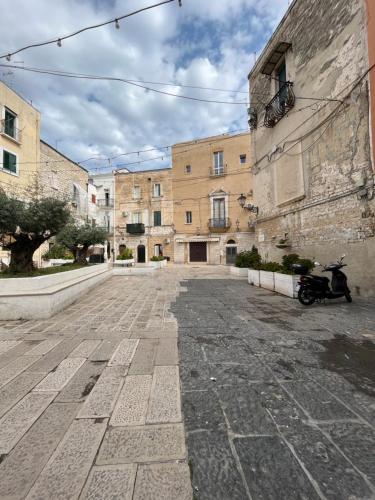 an empty street with a motorcycle parked in front of a building at Piazzetta Degli Innamorati in Bari