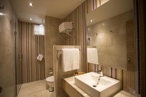 a bathroom with a sink and a toilet and a mirror at Melas Holiday Village in Side