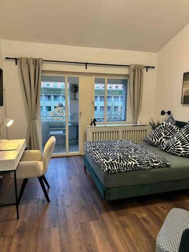 1 dormitorio con cama, escritorio y ventana en Wohnen im Grünen, en Karlsruhe