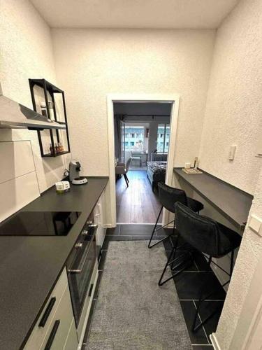 a kitchen with black counter tops and a living room at Wohnen im Grünen in Karlsruhe