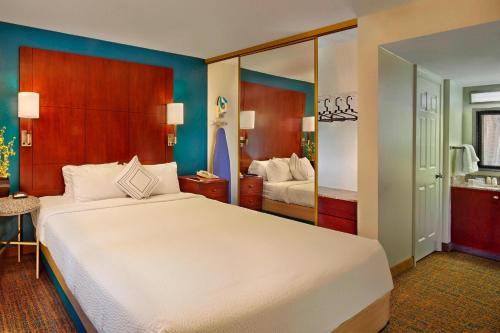 a bedroom with a large white bed and a mirror at Residence Inn Boston Tewksbury/Andover in Tewksbury