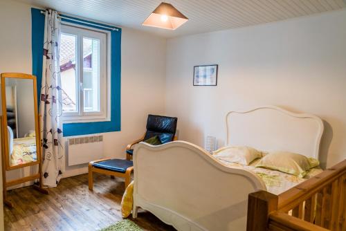 a bedroom with a bed and a chair and a window at Maison agréable en centre historique in Saint-Céré