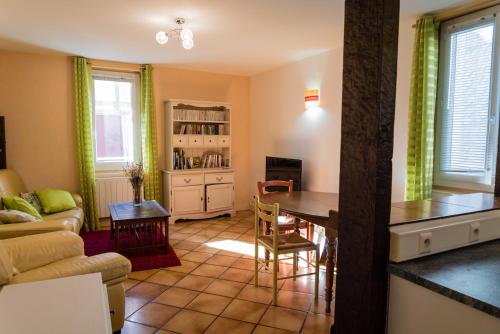 un salon avec une table et un canapé dans l'établissement Maison agréable en centre historique, à Saint-Céré