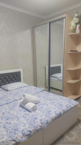 a bedroom with a bed with a blue and white comforter at Сдам квартиру 3-х комнату на Батысе 2 in Aktobe