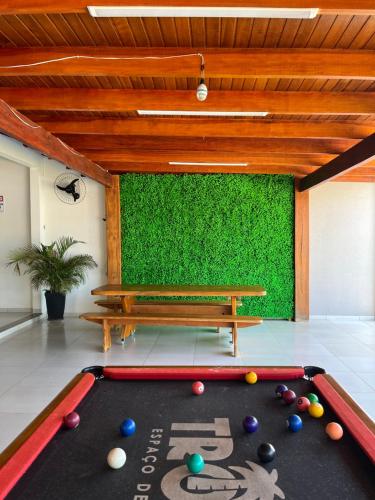 a pool table in a room with a green wall at TROPICAL LAZER E EVENTOS - Casa em Lucas do Rio Verde in Lucas do Rio Verde