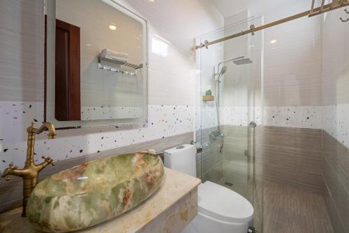 La salle de bains est pourvue d'un lavabo, de toilettes et d'une douche. dans l'établissement Myrtle Boutique Hotel, à Đà Lạt