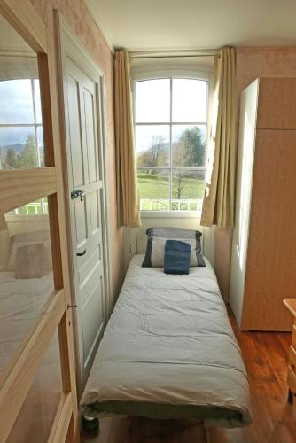 a small bedroom with a bed and two windows at Détente et sport 2 - Chartreuse et Lacs - Chambre chez l'habitant in Saint-Béron