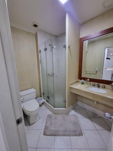 a bathroom with a toilet and a shower and a sink at departamento en la carolina in Quito