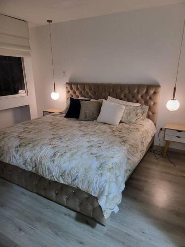 a large bed in a bedroom with two lights at departamento en la carolina in Quito