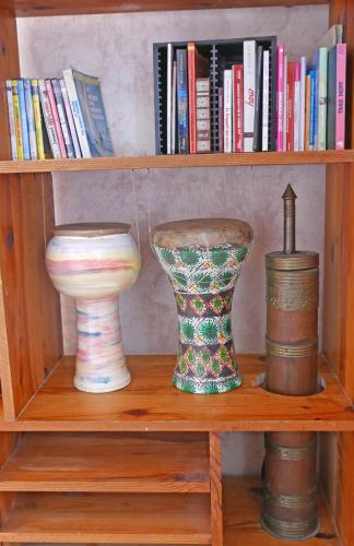 two vases on a wooden shelf with books at Détente et sport 2 - Chartreuse et Lacs - Chambre chez l'habitant in Saint-Béron