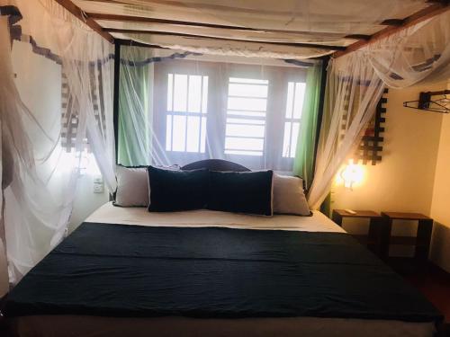 a bedroom with a canopy bed with a window at Unakuruwa silent beach villa in Tangalle
