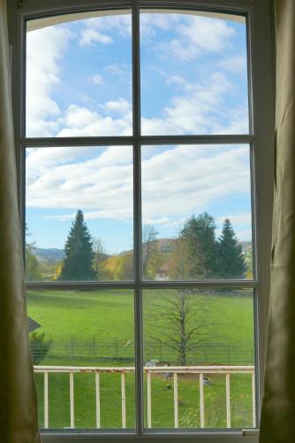 a window with a view of a green field at Détente et sport 2 - Chartreuse et Lacs - Chambre chez l'habitant in Saint-Béron