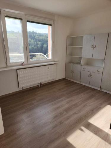 an empty room with a large window and a large kitchen at xxxxxx in Banská Bystrica