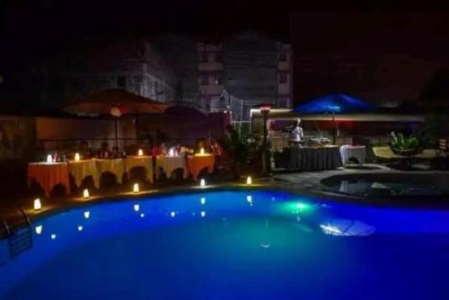 a large blue swimming pool at night with a table at Luna hotel in Nakuru