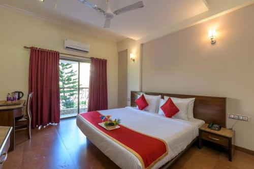 a bedroom with a large bed with red pillows at REVENIIR RESORT Lonavala in Lonavala